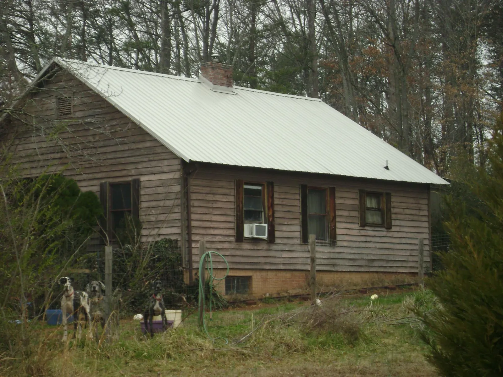 White metal roof on an old wood sided farmhouse, from a Metal Roof Installation job in Latta